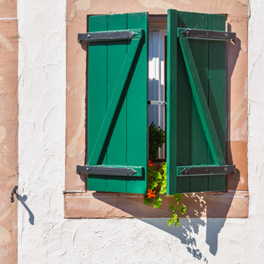 Fenster mit Laden und Geranien